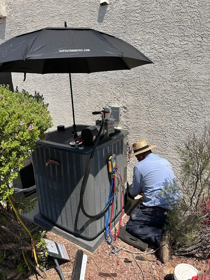 HVAC technician performing outdoor AC maintenance in Hoover