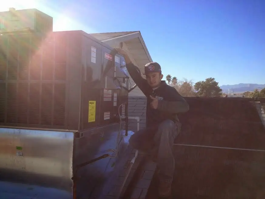 HVAC technician performing Heat Pump Repair on a rooftop unit in Hoover